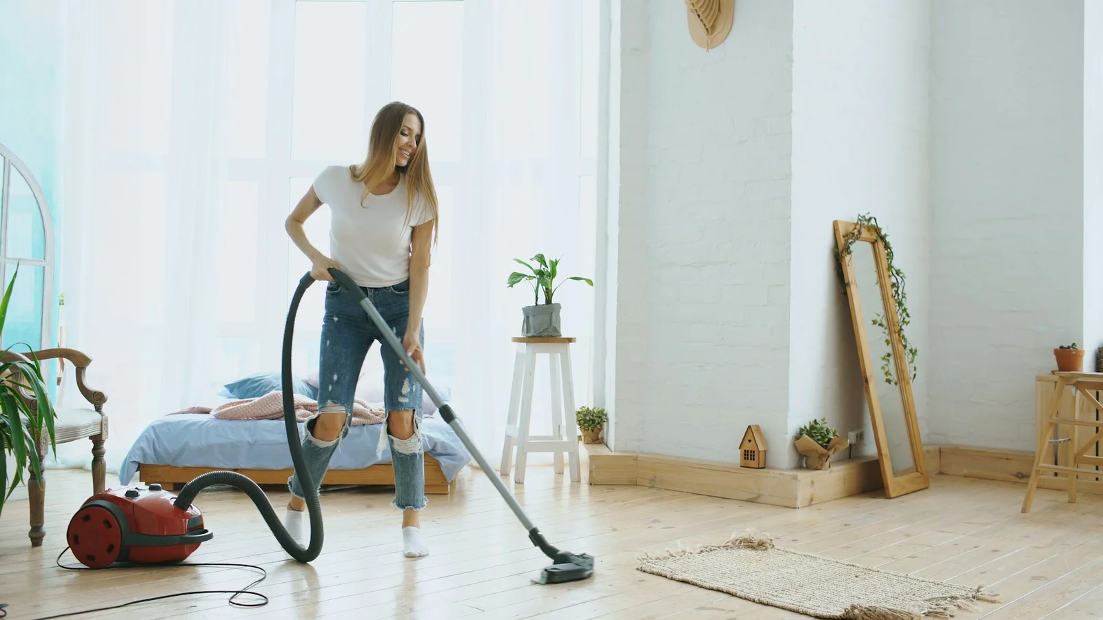 A bright living room being vacuumed